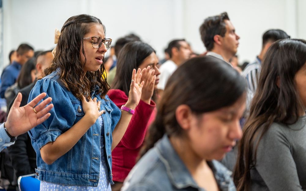A woman worshipping among the congregation on a Sunday morning